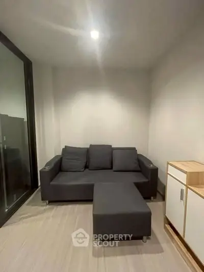 Cozy modern living room with sleek black sofa and minimalist decor