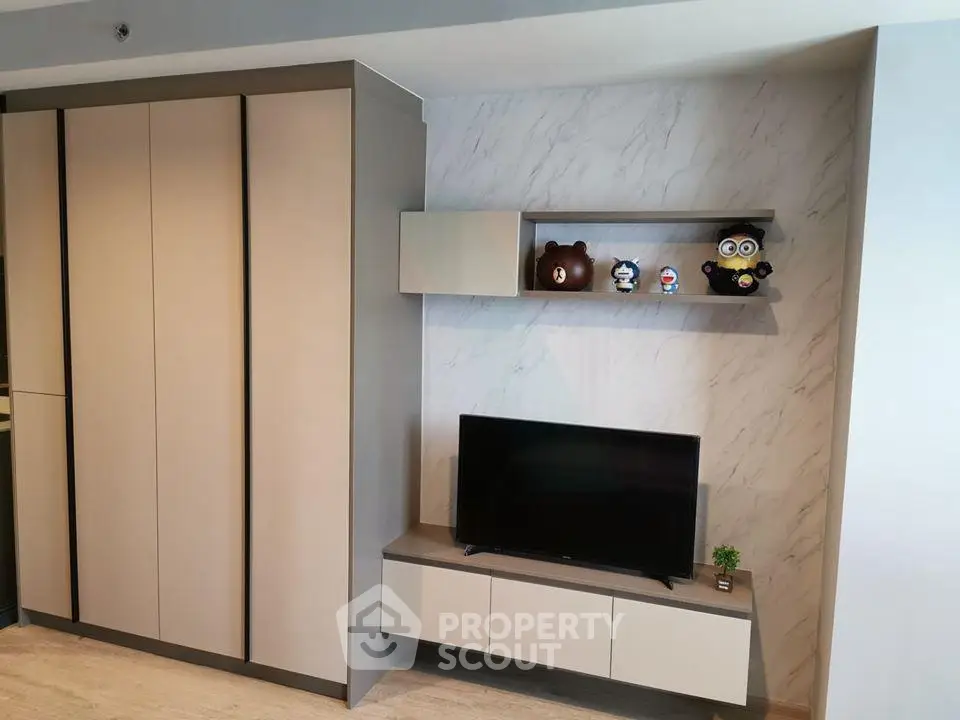 Modern living room with sleek storage and TV unit, featuring stylish decor and minimalist design.