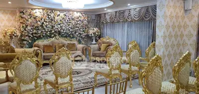 Luxurious living room with ornate gold furniture and floral wall decor