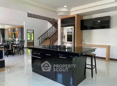 Spacious modern kitchen with sleek black island and open layout in luxury home