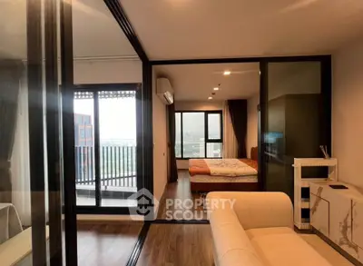 Modern apartment with glass partitions, cozy bedroom, and balcony view.