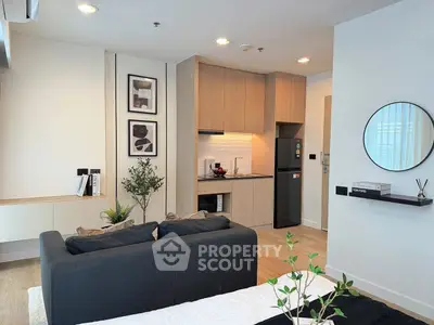 Modern living room with open kitchen, stylish decor, and cozy ambiance in a contemporary apartment.