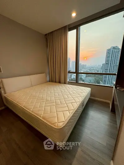 Modern bedroom with city view and large window, featuring a comfortable bed and elegant decor.
