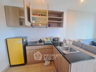 Modern kitchen with wooden cabinets and yellow fridge in cozy apartment