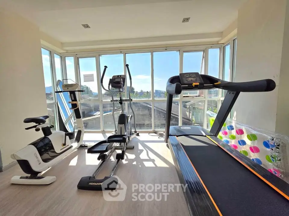 Bright and modern gym with exercise equipment and scenic views.