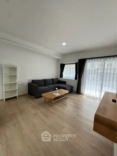 Spacious modern living room with large windows and stylish furniture, perfect for relaxation and entertaining.