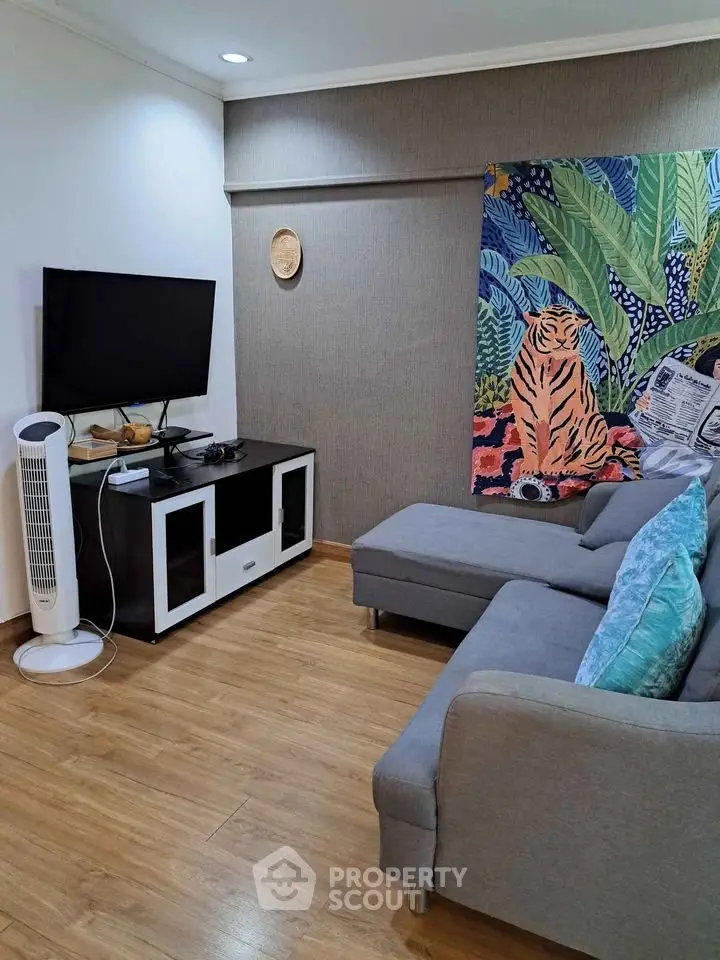 Cozy living room with modern decor and stylish furniture, featuring a vibrant wall tapestry.