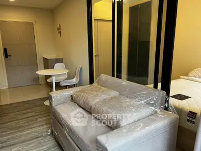 Modern studio apartment with cozy living area and compact dining space.