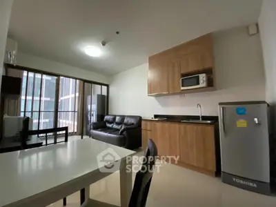 Modern open-layout kitchen and living area with sleek furniture and appliances.