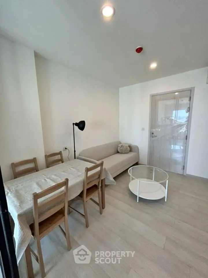 Modern living room with cozy sofa, dining table, and stylish decor in a bright apartment.