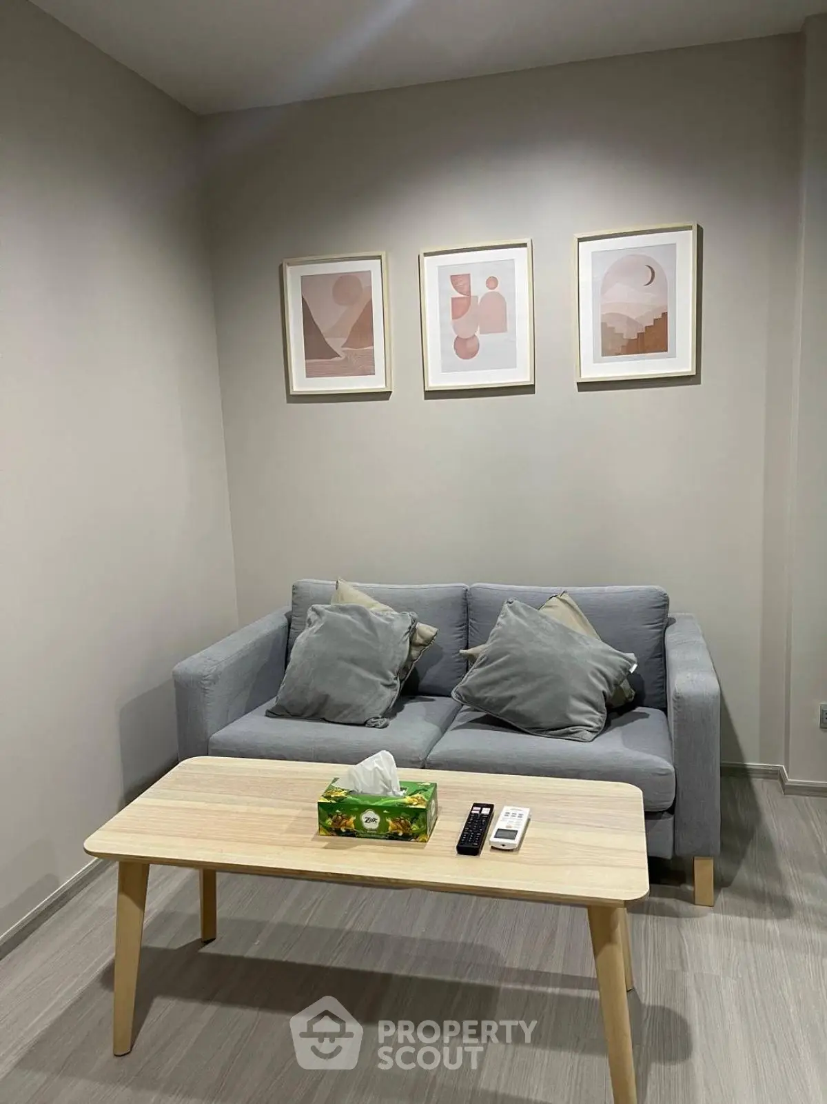 Cozy living room with modern gray sofa and stylish artwork on the wall.