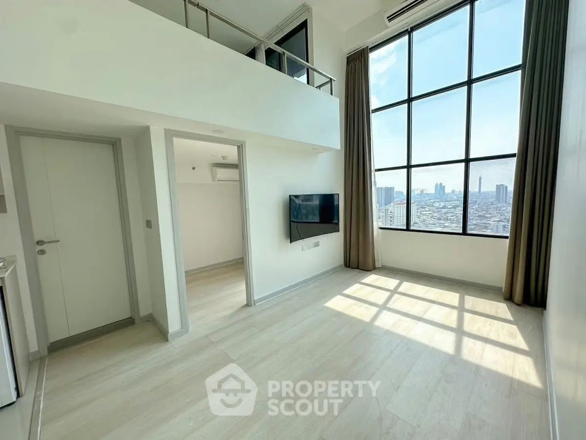 Spacious modern living room with high ceilings and city view, featuring large windows and natural light.