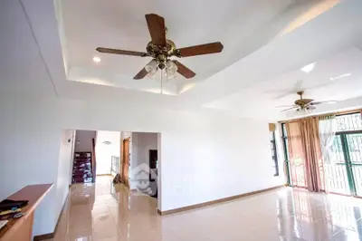 Spacious living room with ceiling fans and natural light