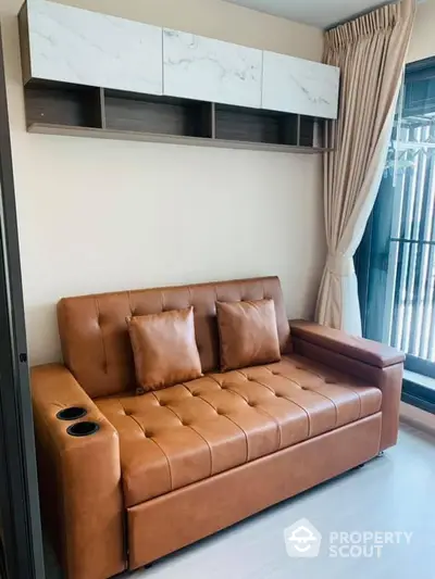 Modern living room with stylish brown leather sofa and elegant wall-mounted storage