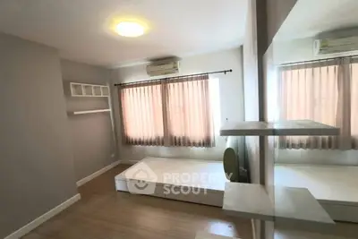 Spacious bedroom with large windows and modern decor, perfect for comfortable living.