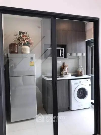 Modern kitchen with sleek appliances and stylish cabinetry in a compact layout.