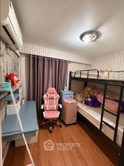 Cozy bedroom with bunk bed, study desk, and stylish chair, perfect for a compact living space.