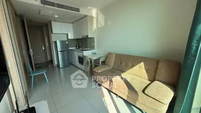 Modern living room with cozy sofa and compact kitchen in open layout apartment