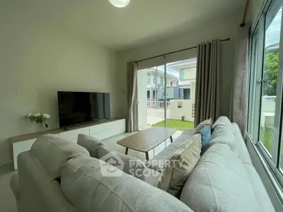 Cozy living room with large window and modern furniture in a bright home.