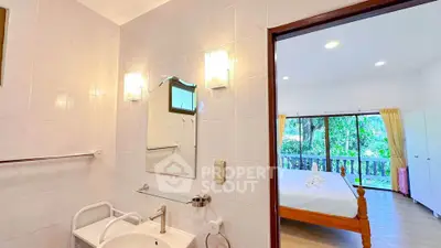 Spacious bedroom with attached bathroom and scenic garden view, perfect for serene living.