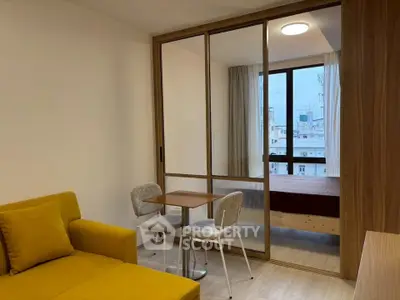 Modern apartment with cozy living area and glass partitioned bedroom.