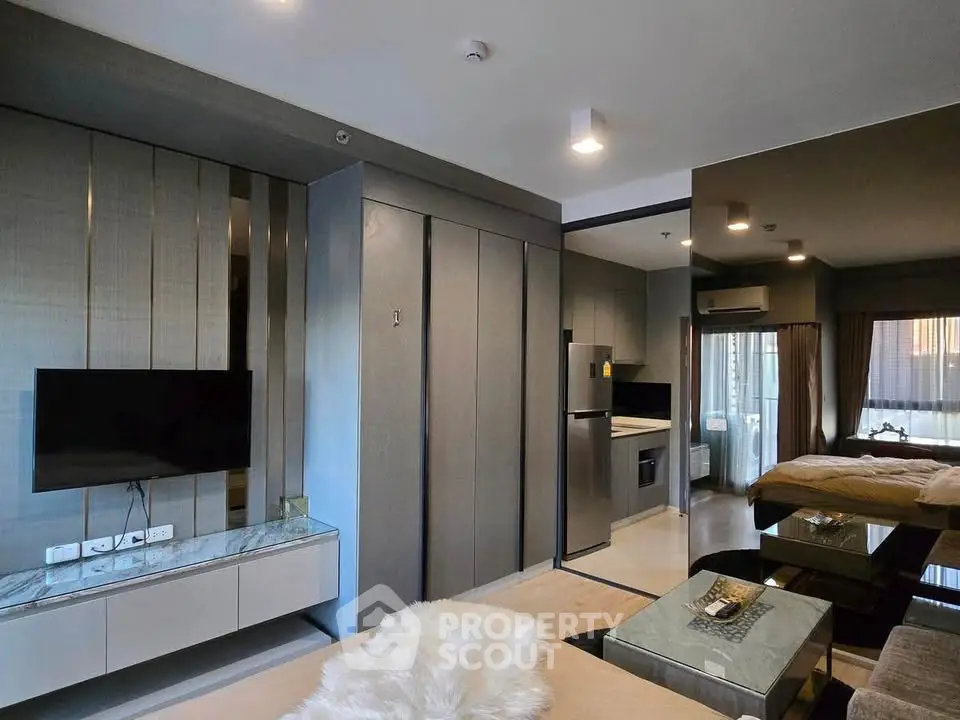 Modern studio apartment with sleek design and open layout, featuring a cozy living area and stylish kitchen.