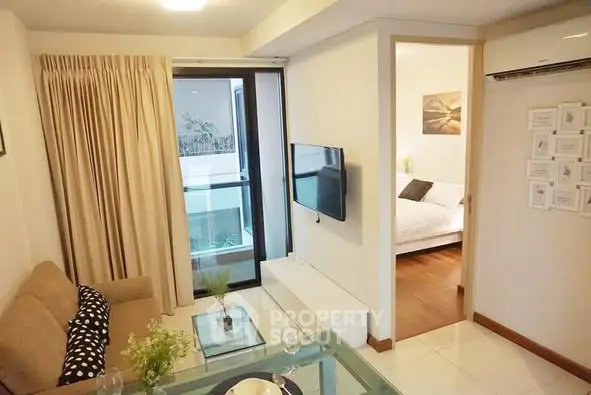 Cozy living room with modern decor and balcony access in a stylish apartment.