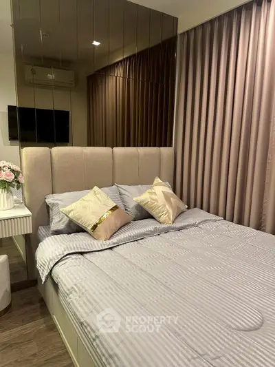 Cozy bedroom with elegant decor and plush bedding in modern apartment.