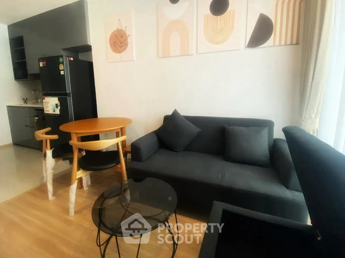 Modern living room with stylish furniture and art decor, featuring a cozy sofa and dining area.