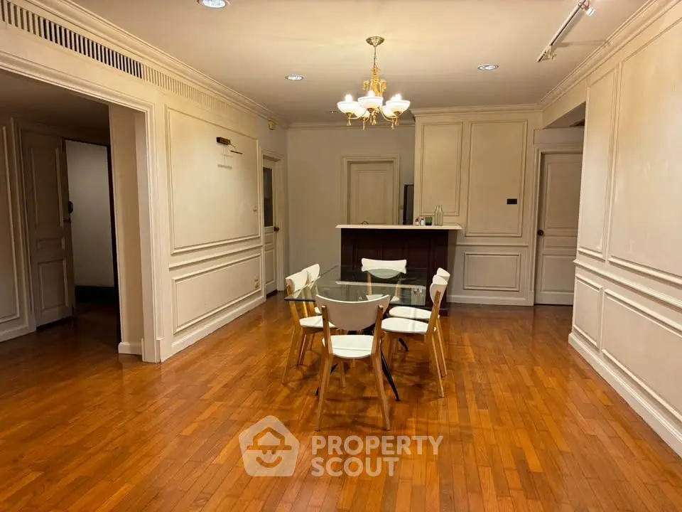 Spacious dining area with elegant wooden flooring and modern chandelier