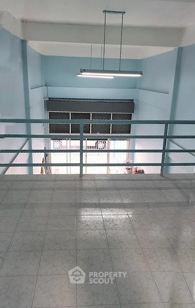 Spacious industrial-style loft with high ceilings and large windows, perfect for creative workspace or studio.