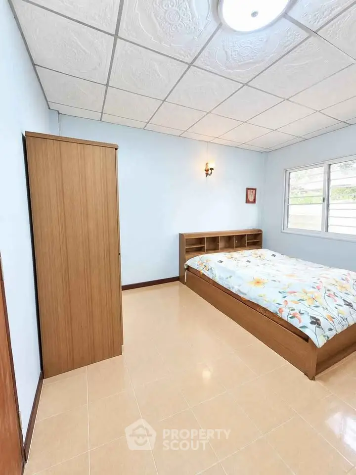 Spacious bedroom with natural light and modern furnishings in a serene setting.