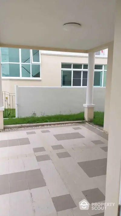 Modern covered patio with tiled flooring and garden view in contemporary home