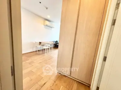 Spacious modern living area with wooden flooring and minimalist furniture