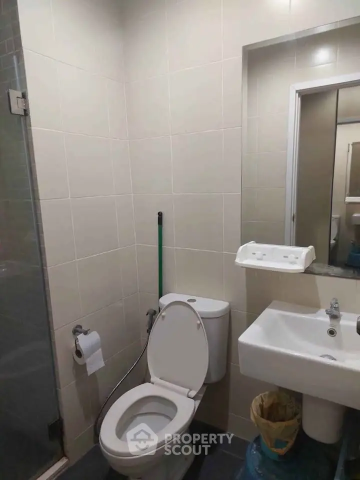 Modern bathroom with shower, toilet, and sink in a compact layout.