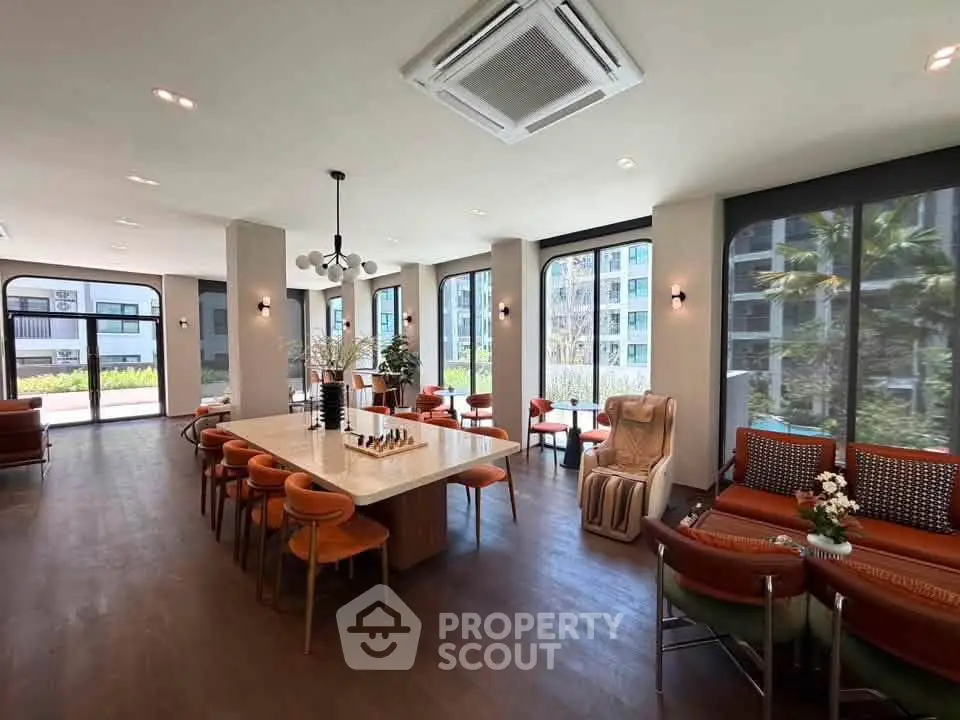 Spacious modern living area with elegant furniture and large windows offering garden views.