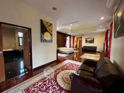 Spacious living room with elegant decor and open layout, featuring leather sofas and vibrant rugs.