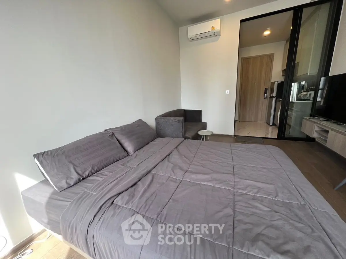 Modern bedroom with sleek design and natural light, featuring a cozy bed and minimalist decor.
