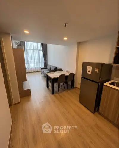 Modern living room with dining area and kitchen in open layout apartment.