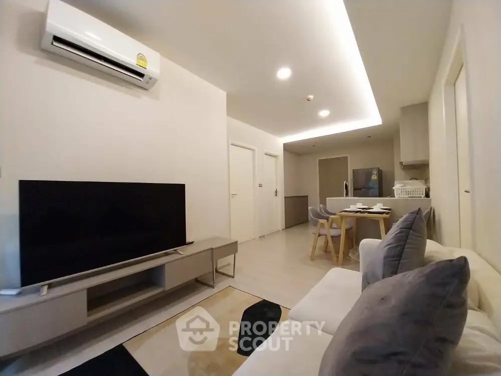Modern living room with sleek furniture and ambient lighting in a cozy apartment.