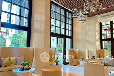 Luxurious modern lobby with elegant seating and large windows in upscale building.