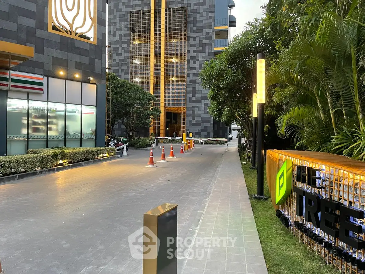 Modern building entrance with lush greenery and sleek architecture