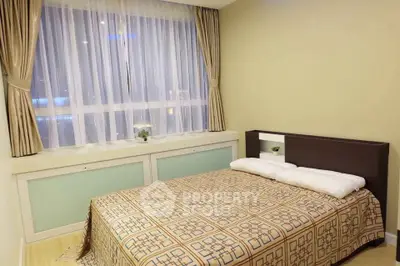 Cozy bedroom with large window and elegant curtains in modern apartment.