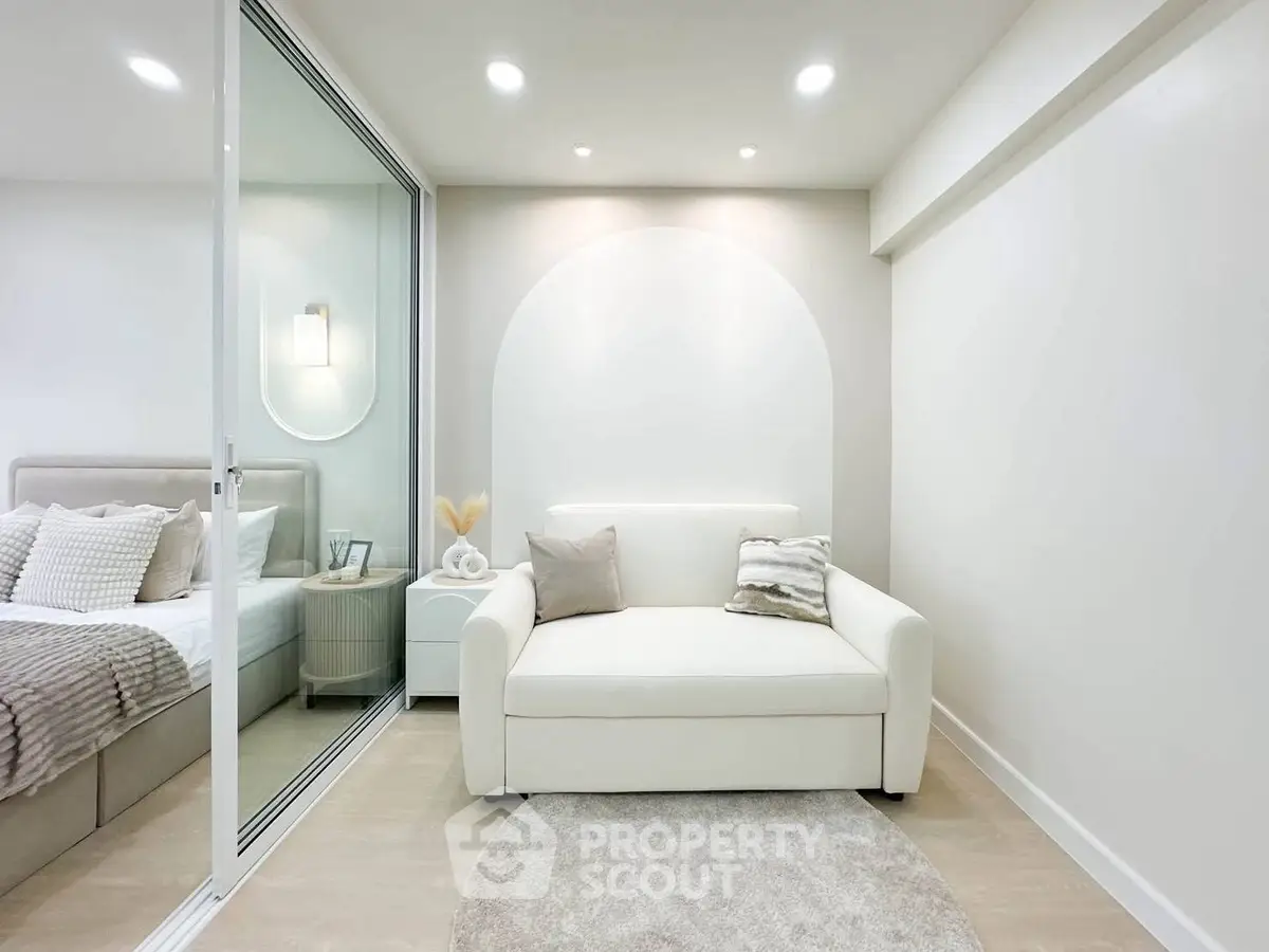Modern minimalist bedroom with cozy seating area and elegant decor