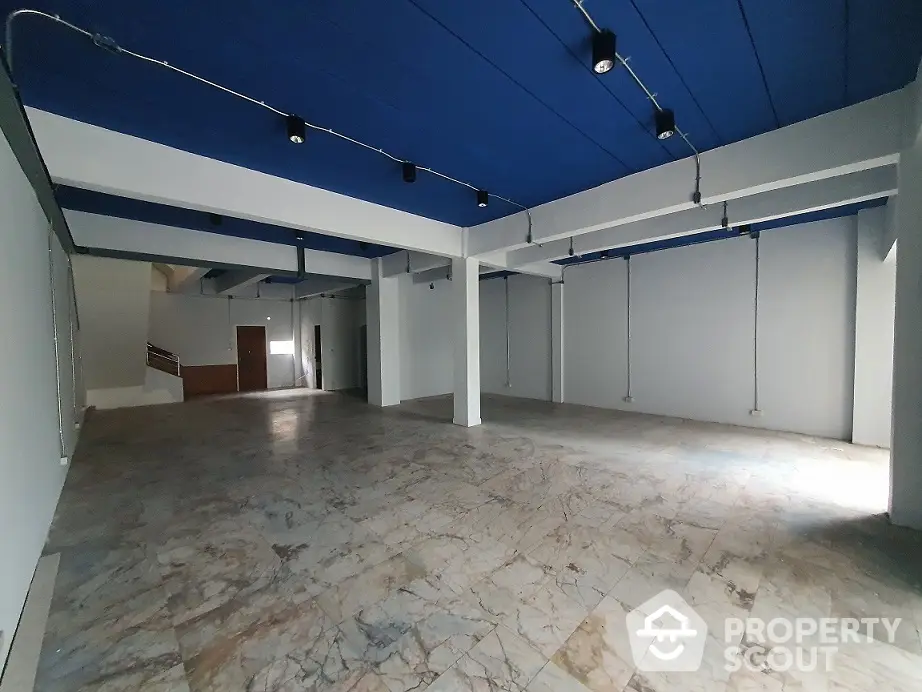 Spacious open-plan commercial space with modern lighting and marble flooring