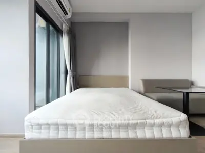 Modern bedroom with minimalist design, featuring a comfortable bed and large window for natural light.
