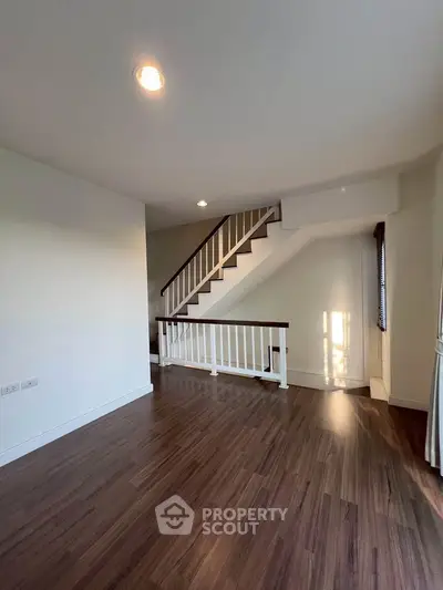 Spacious interior with elegant wooden flooring and staircase, perfect for modern living.