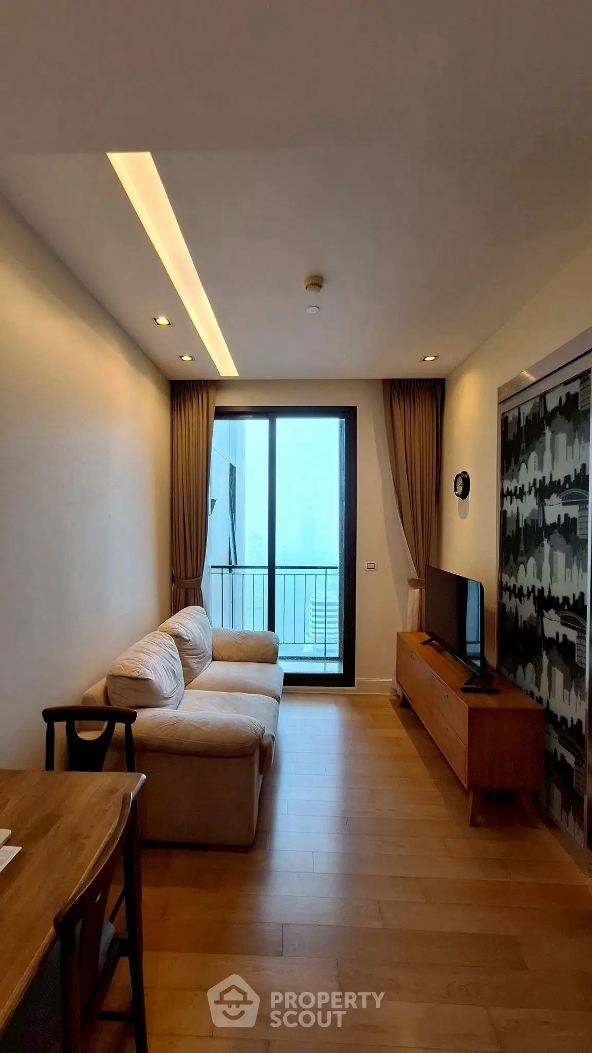 Cozy living room with modern furniture and balcony access, perfect for relaxation and entertainment.