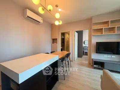 Modern living room with stylish furniture and open layout, featuring a dining area and wall-mounted TV.