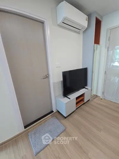 Modern living room with sleek TV stand and air conditioning unit, perfect for cozy relaxation.